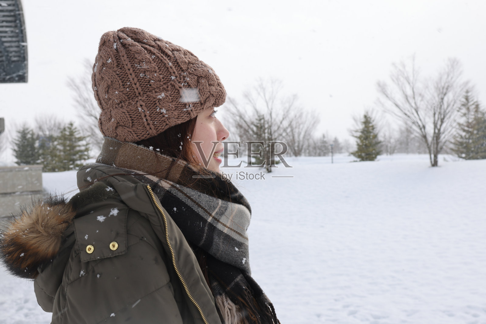 美丽的年轻女子在白雪覆盖的公园放松照片摄影图片