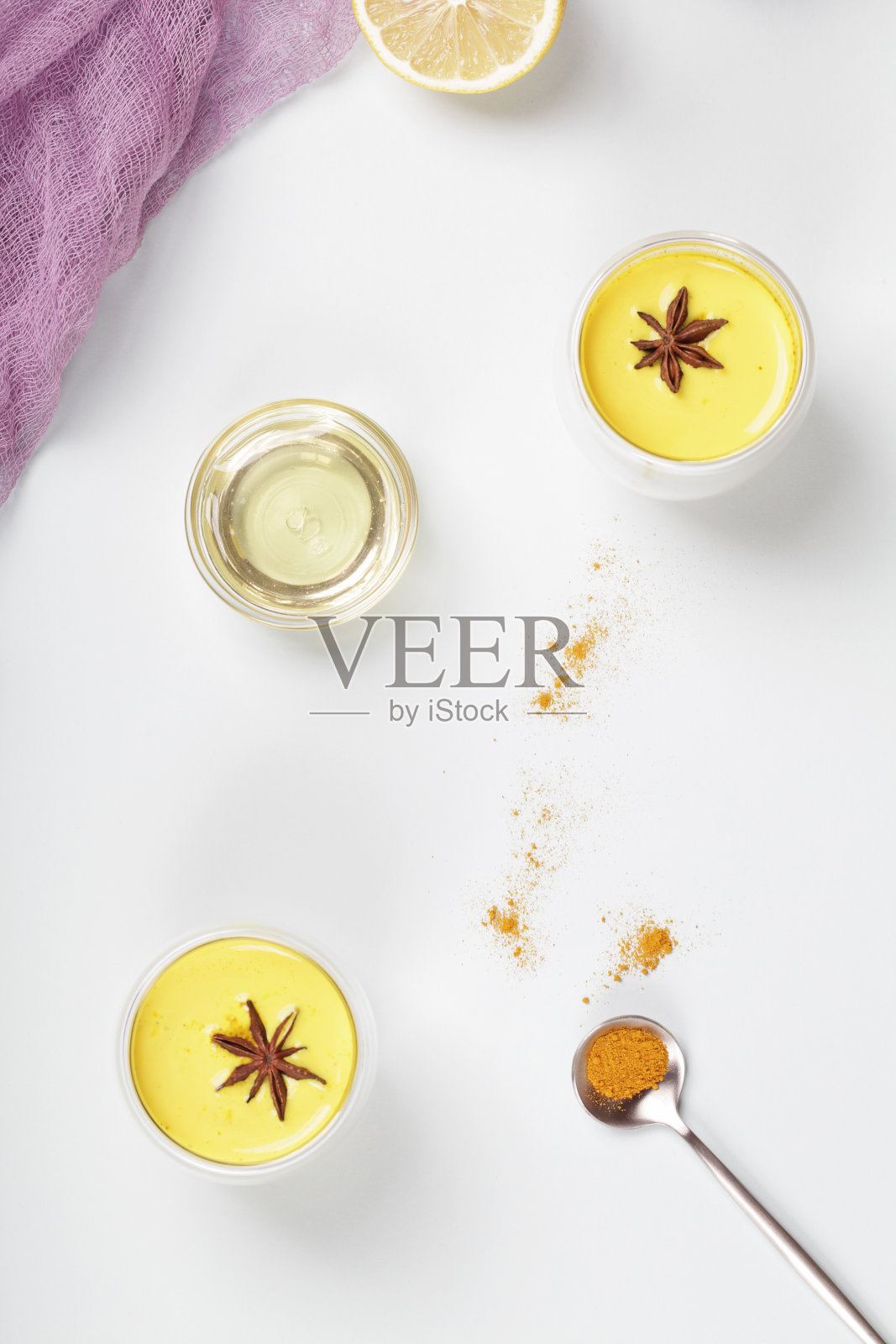 姜黄、金色奶粉、蜂蜜、柠檬和纺织品在蓝色背景。替代医学概念。俯视图平铺照片摄影图片