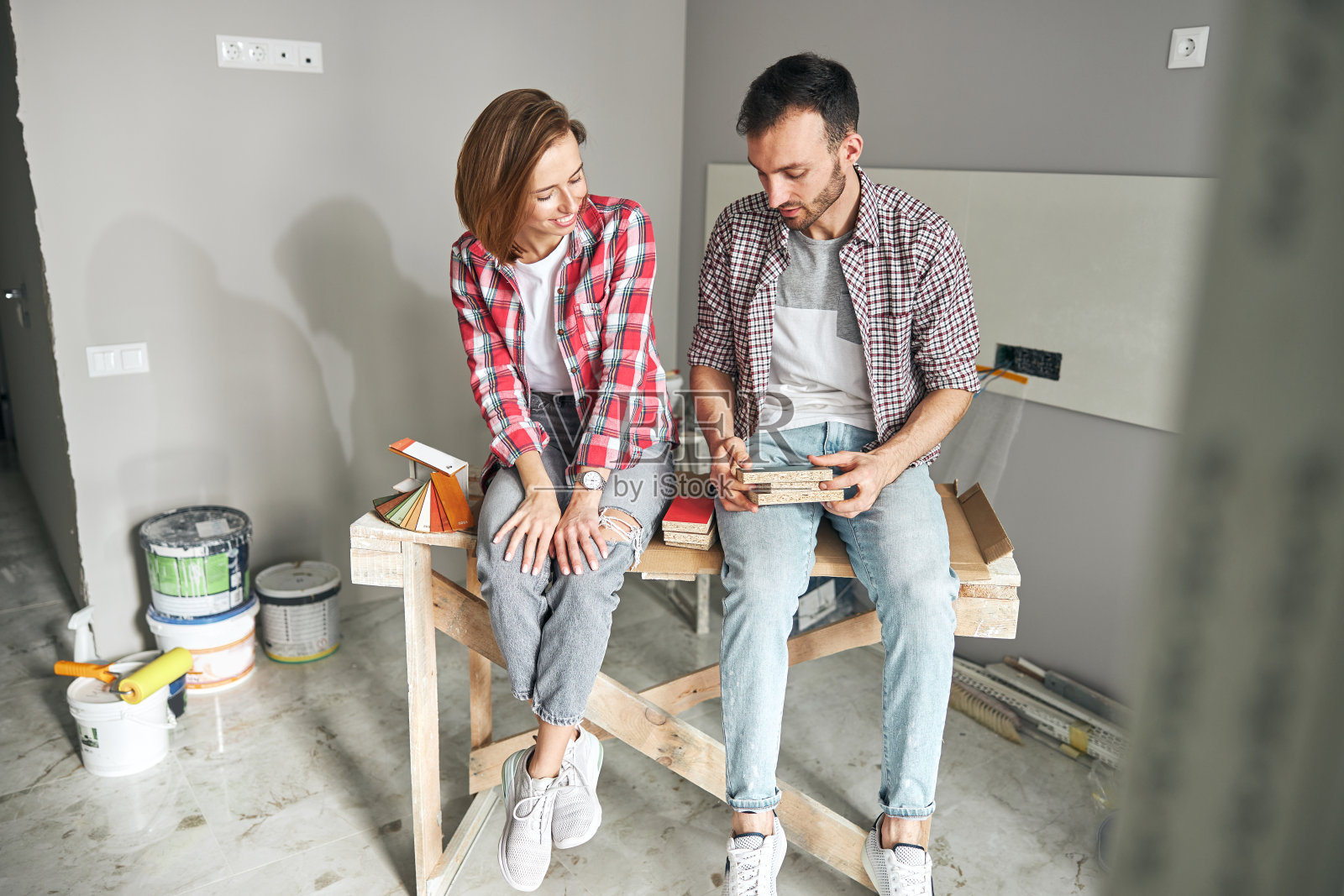 两个熟练的年轻工人在讨论地板材料照片摄影图片