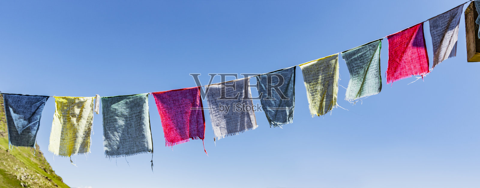 蓝色的天空映衬着五颜六色的经幡照片摄影图片