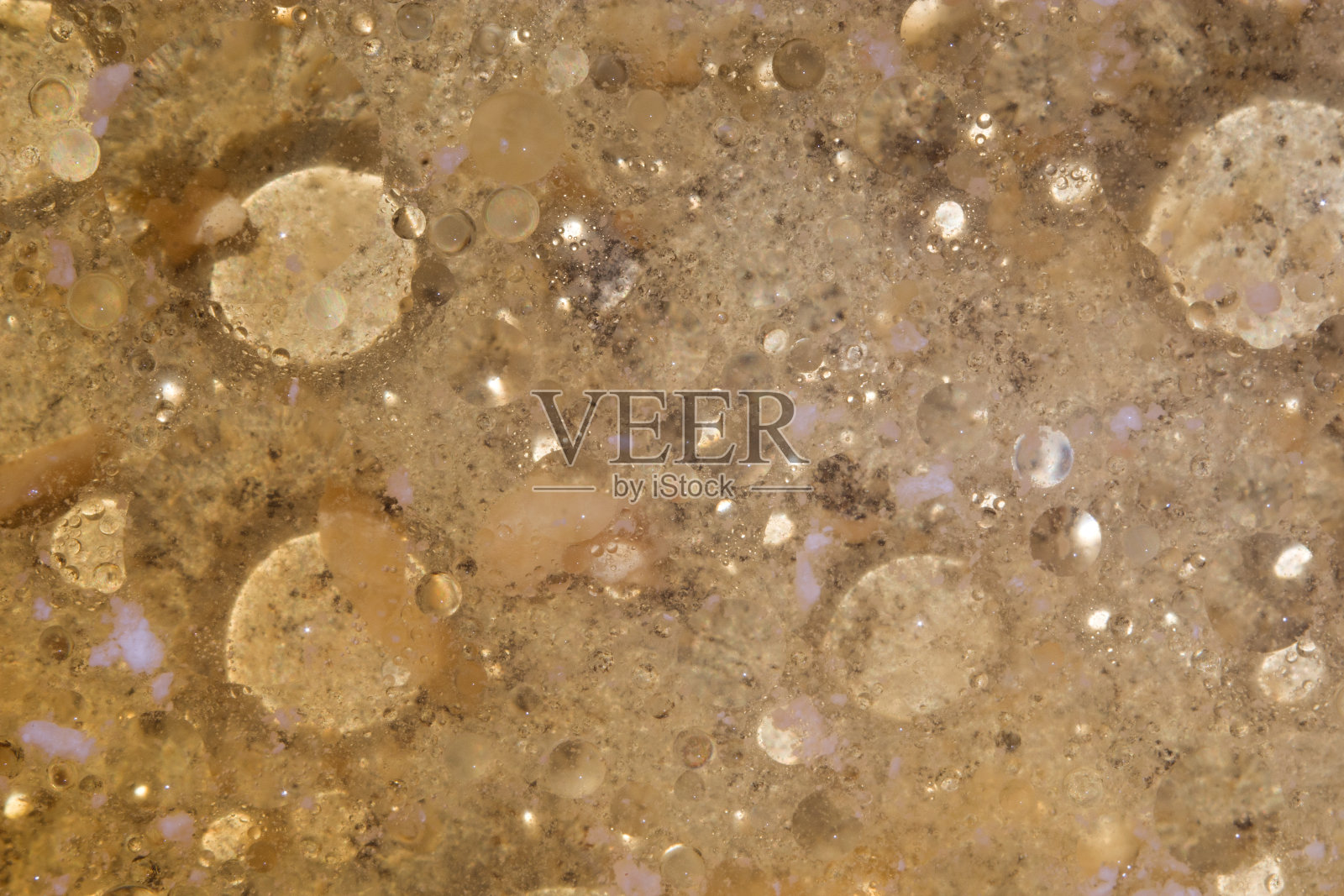 油滴在水面上。棕色的空间背景。水面上有污迹和圆圈。从以上观点。Copyspace照片摄影图片