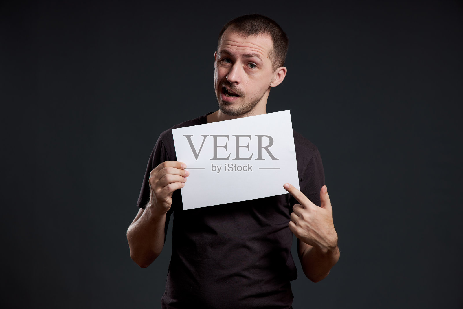 一个人手里拿着一张空的海报纸。微笑和欢乐，放置文字，复制空间照片摄影图片