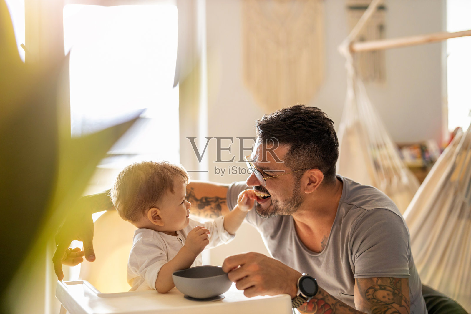 单亲爸爸在喂他的孩子照片摄影图片