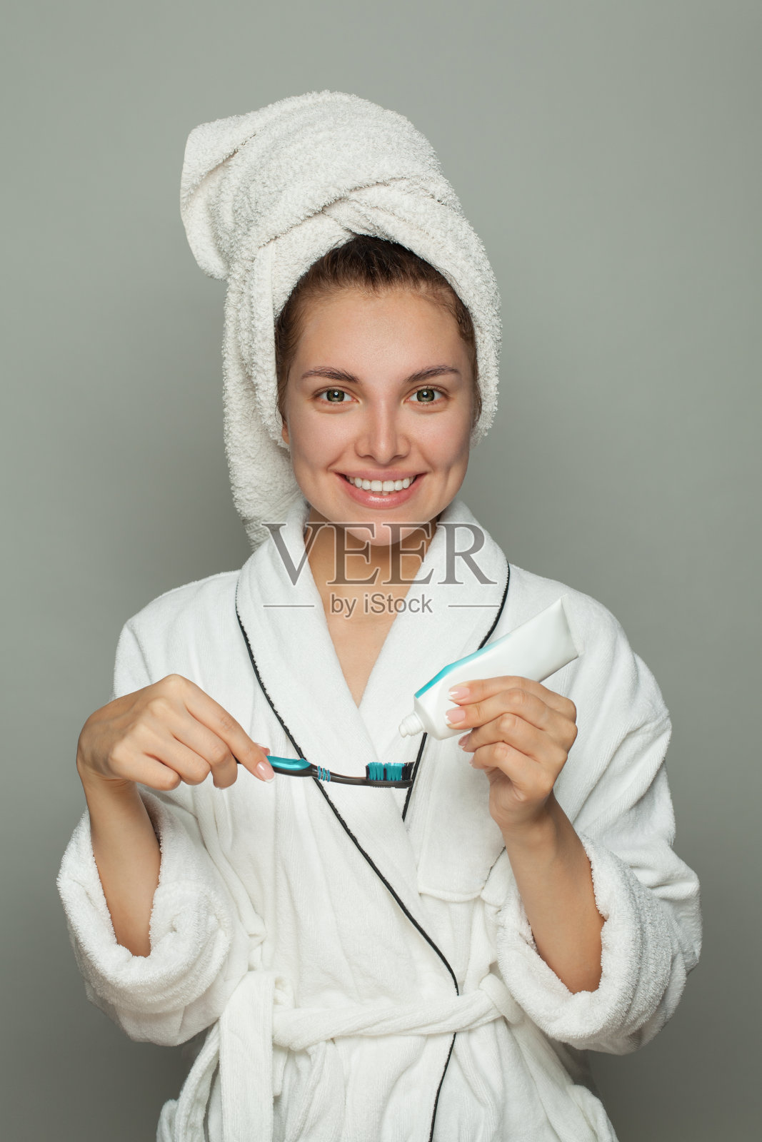 微笑的温泉女人用牙膏刷牙照片摄影图片