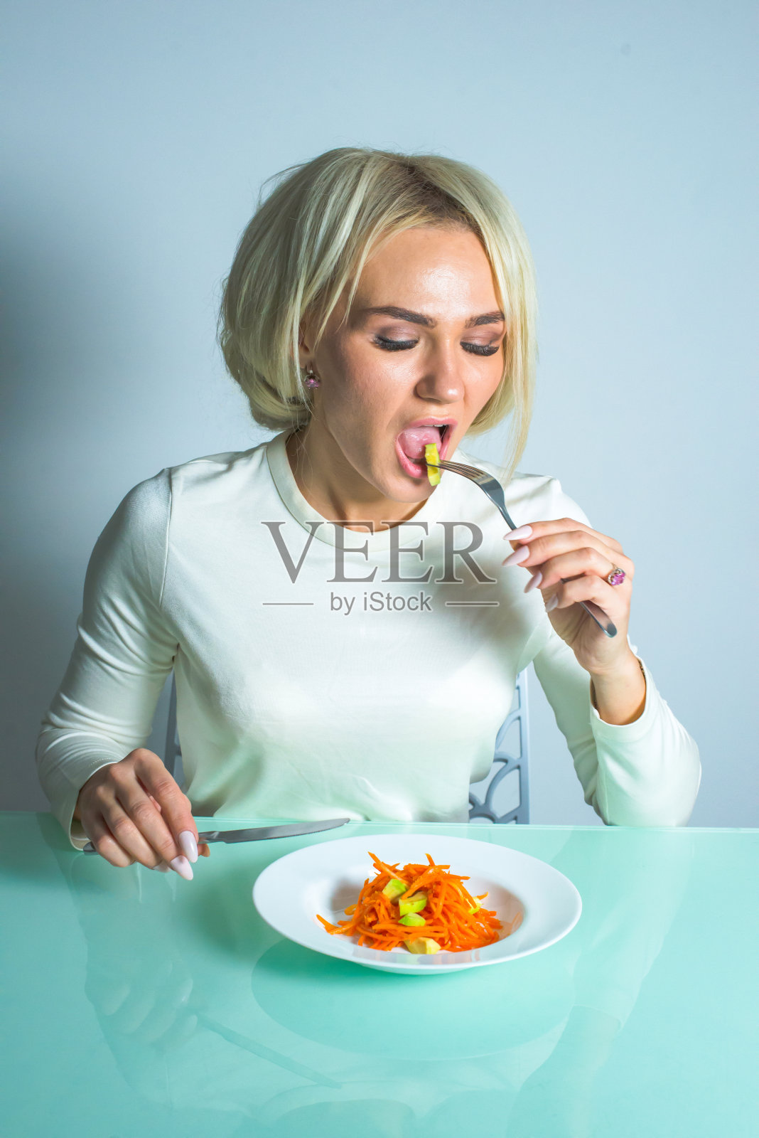 小女孩在厨房里吃着美味的沙拉。照片摄影图片