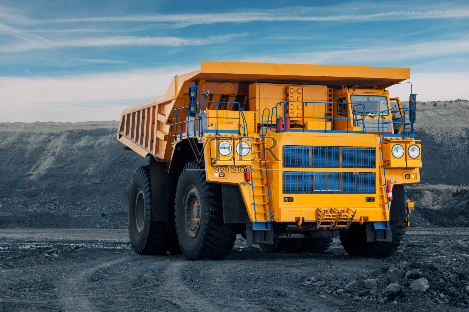 煤矿里的一辆大型自卸车。把煤装进车里。矿石运输用的采矿设备。照片摄影图片