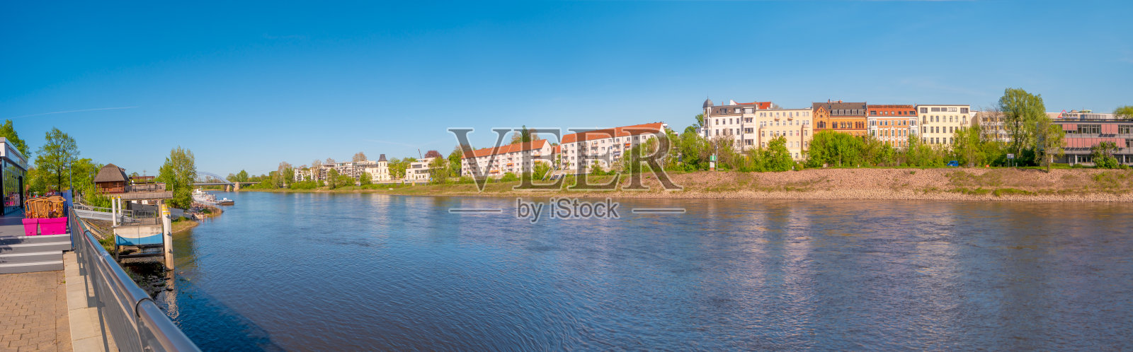 海滩咖啡馆、餐厅和其他地标性建筑的全景，历史悠久的市中心和易北河在春天，马格德堡，德国。照片摄影图片