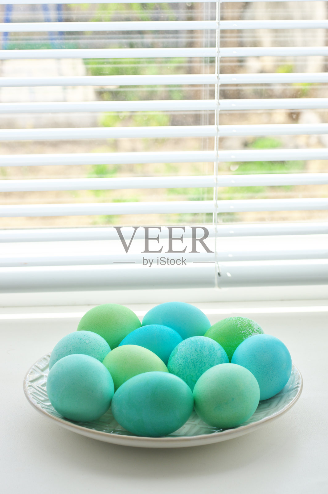 盘子里有浅蓝色和绿色的复活节彩蛋照片摄影图片