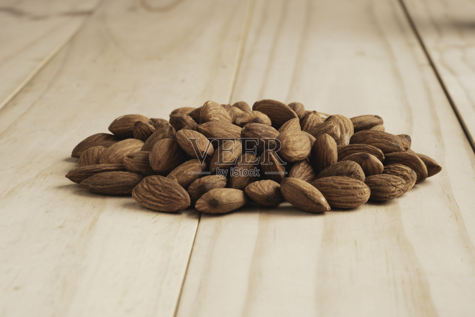 杏仁堆在有拷贝空间的木桌上。杏仁是一种高蛋白、低脂肪和必需氨基酸的健康饮食食品。照片摄影图片