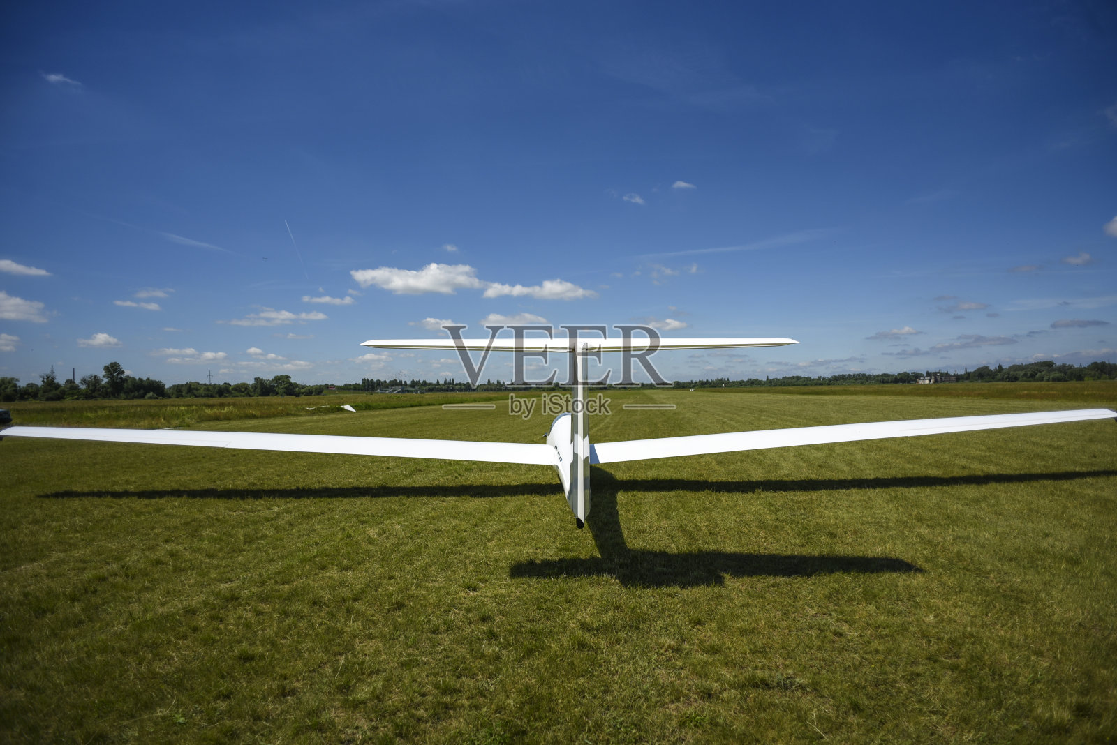 一架滑翔机降落在什切青阳光明媚的草地上。照片摄影图片