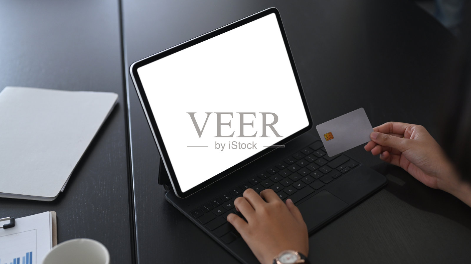 近距离观看女商人手持信用卡，使用平板电脑在线购物或网上银行。照片摄影图片