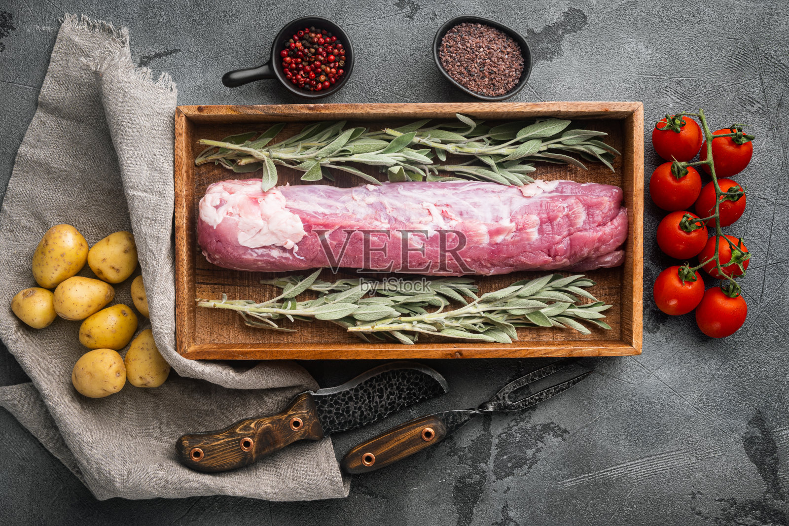 全无骨猪里脊与配料和药草烤架，在木盒子里，灰色的石头背景，俯视图平铺照片摄影图片