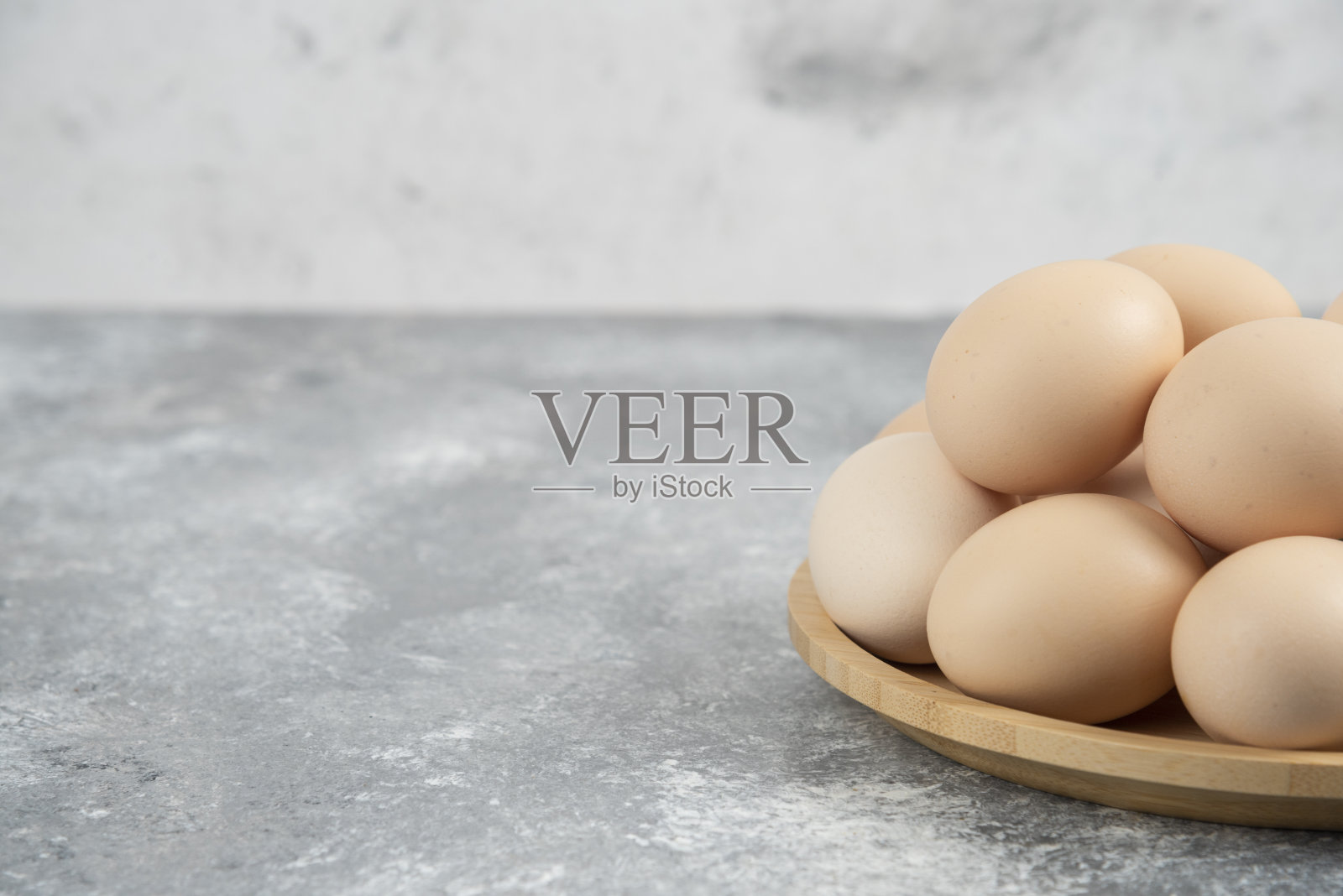 大理石表面的新鲜有机生鸡蛋木制盘子照片摄影图片