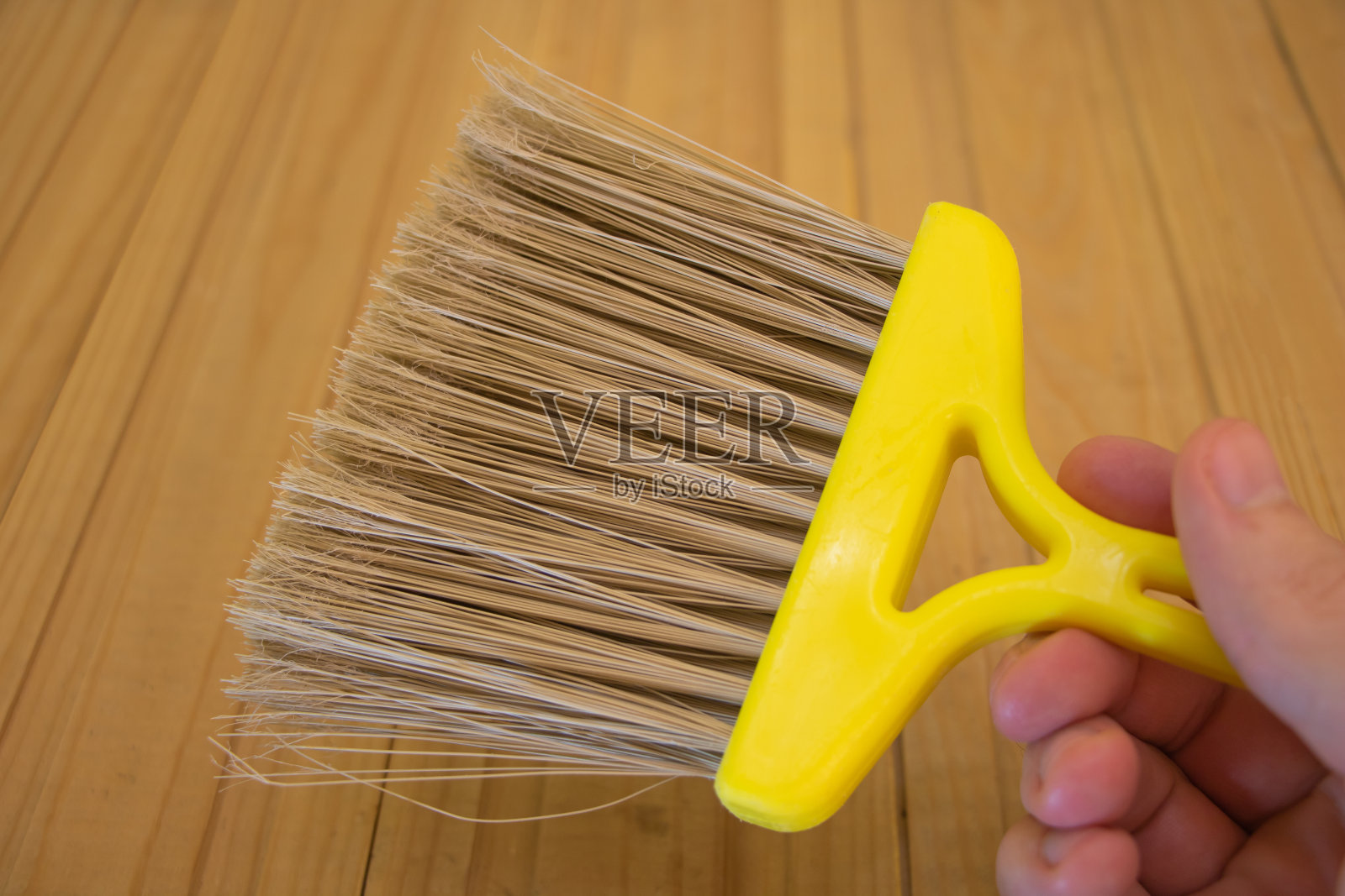 一个手握刷子的人在木制背景上照片摄影图片