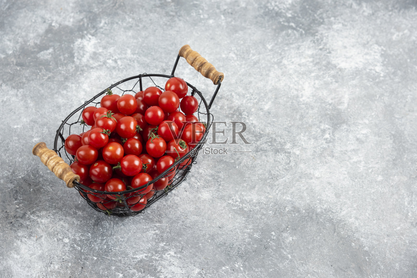 大理石背景上的金属篮子里的樱桃番茄照片摄影图片