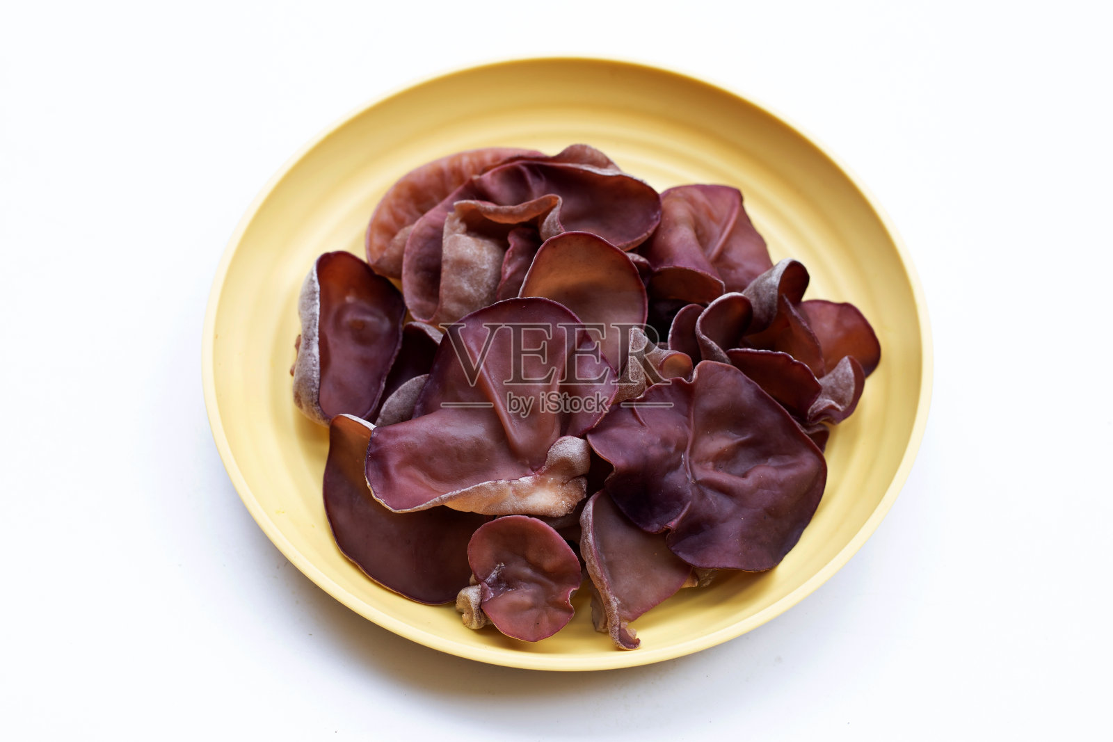 黑木耳放在黄盘上，白盘上。照片摄影图片