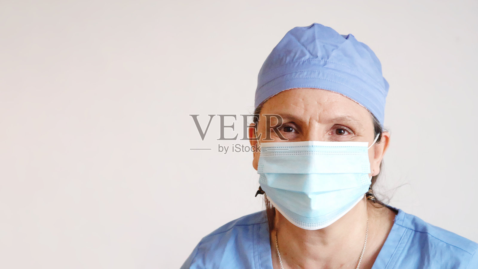 成熟的女护士肖像在她的防护面具后温柔微笑照片摄影图片