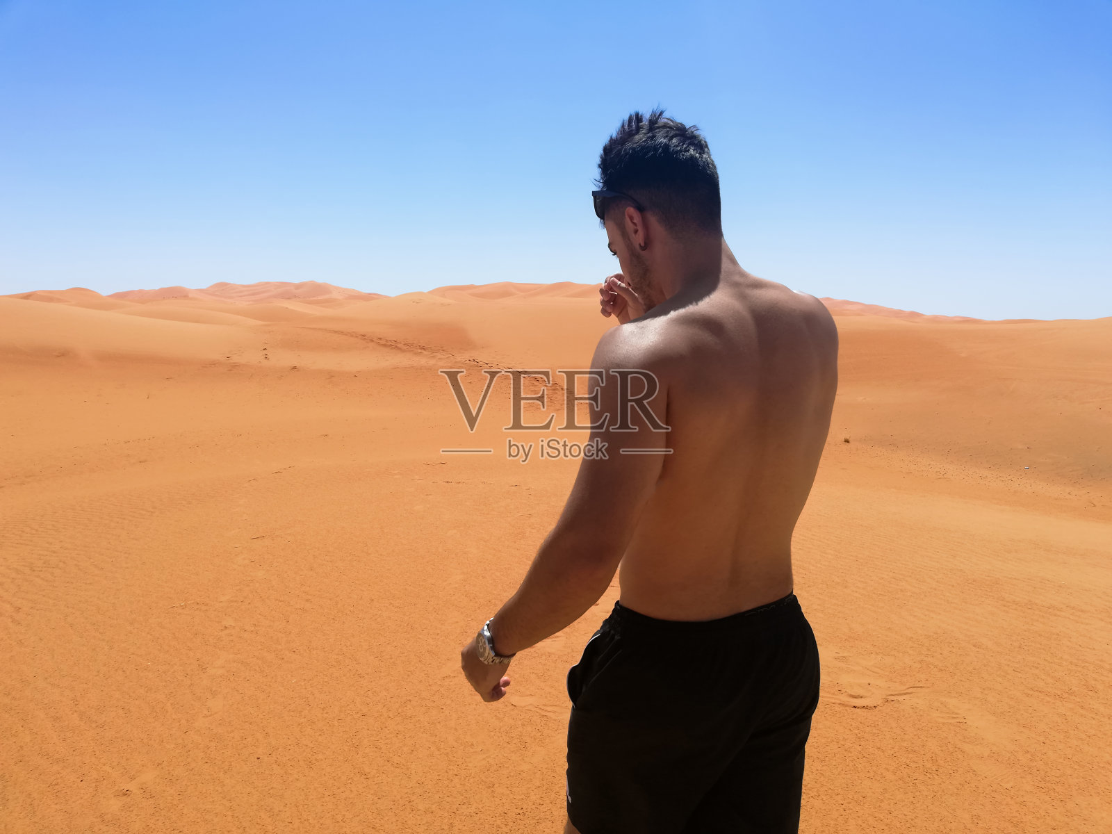 赤膊行走在撒哈拉沙漠照片摄影图片