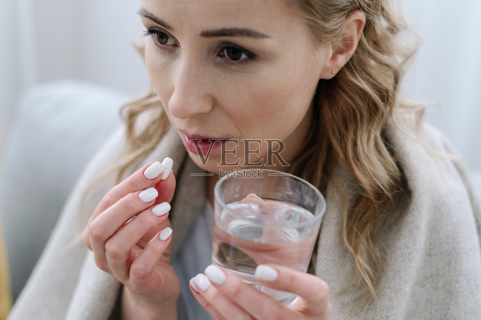 病魔缠身的女子服下白色药丸照片摄影图片