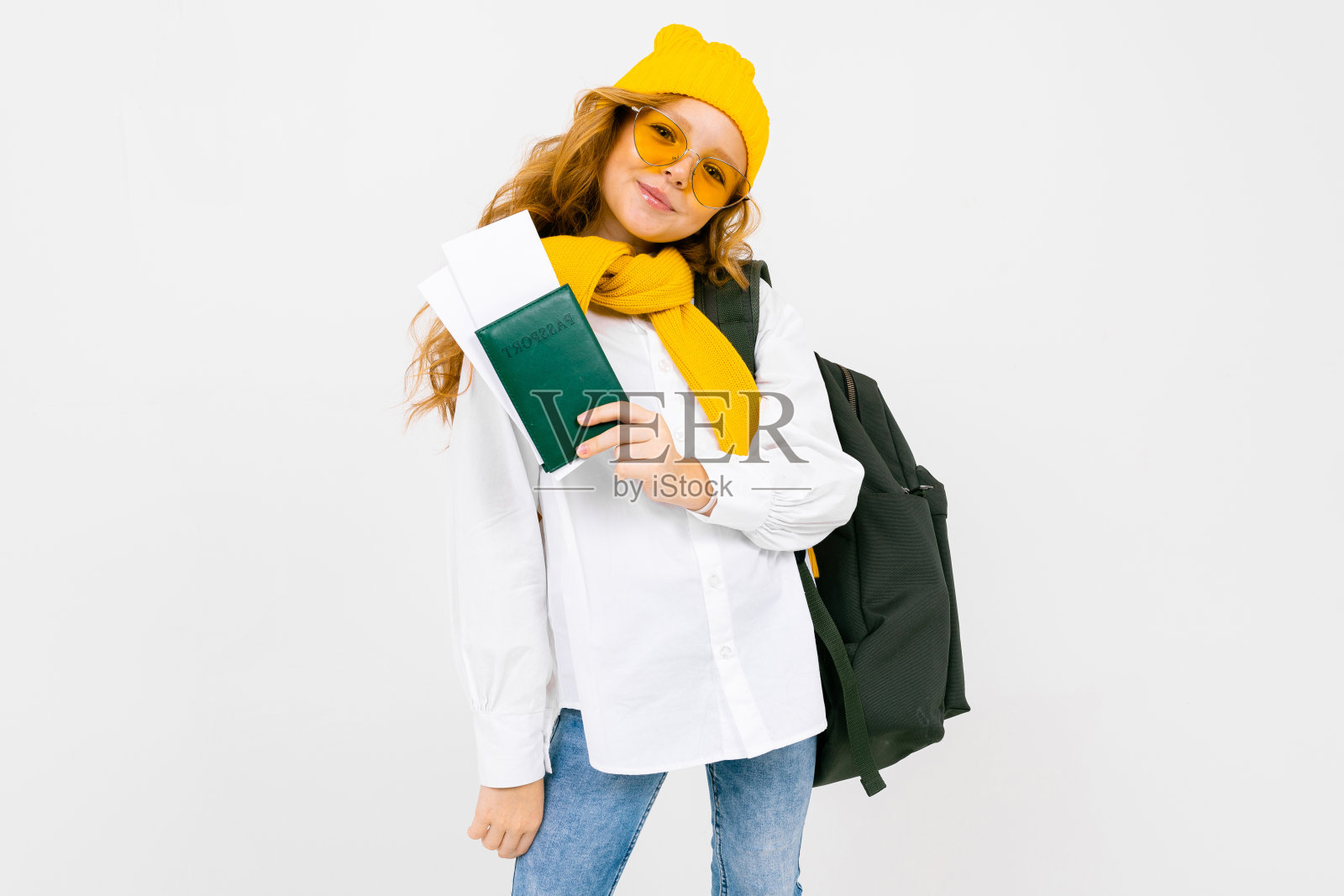 女孩肩上背着背包，手里拿着一本护照，上面印着其他人的机票，背景是白色的，还有复印空间照片摄影图片