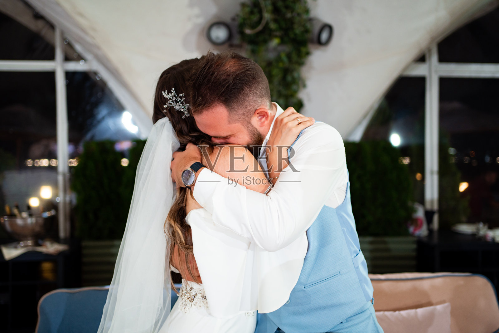 新婚夫妇在餐厅亲吻拥抱，聆听客人的祝贺。照片摄影图片