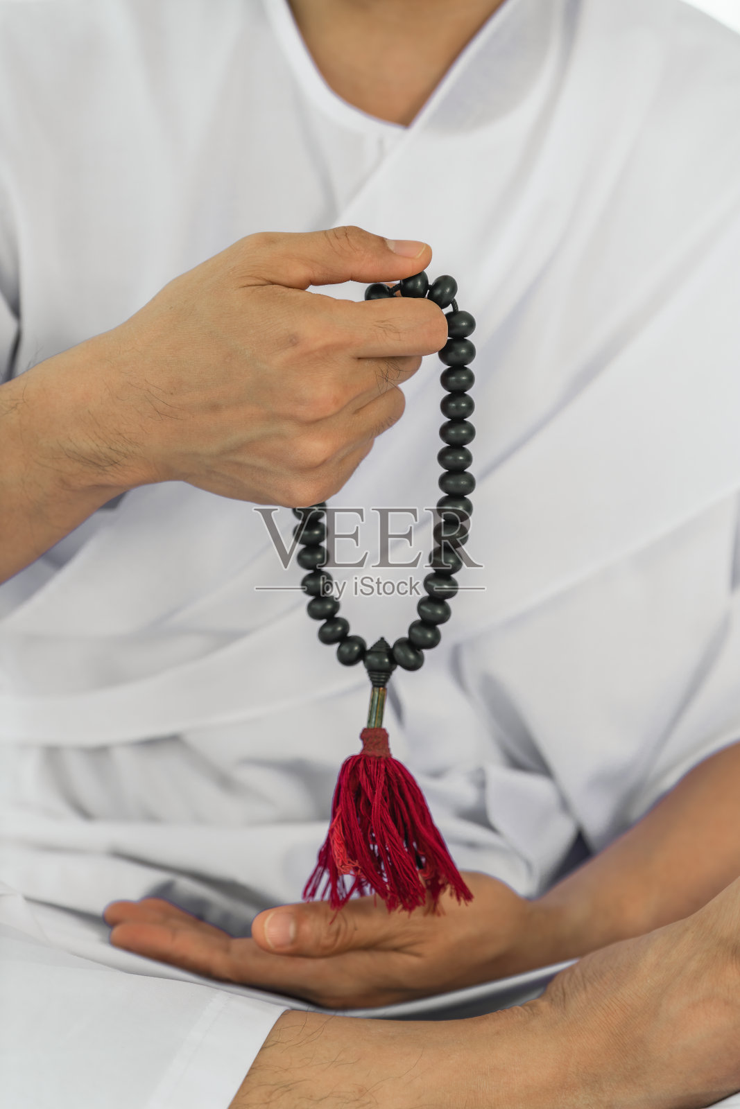 手持黑念珠的虔诚佛教徒在白衣中坐着念珠计数冥想照片摄影图片