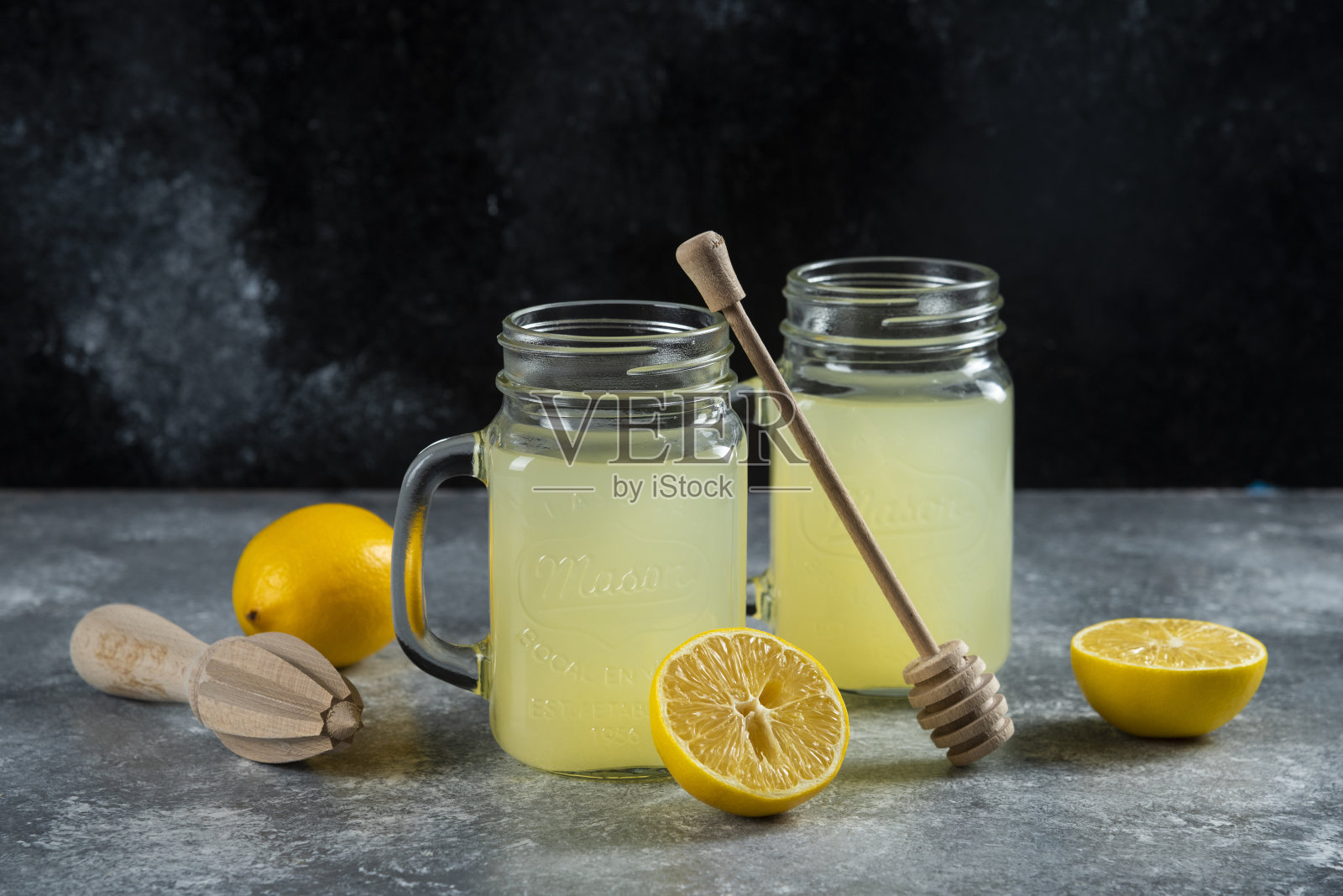 大理石背景上放着两瓶柠檬汁和柠檬片照片摄影图片