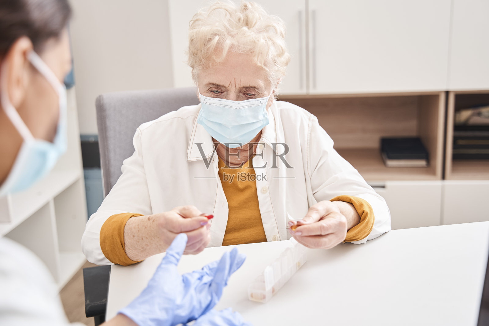 医生给生病的老年女性开药照片摄影图片