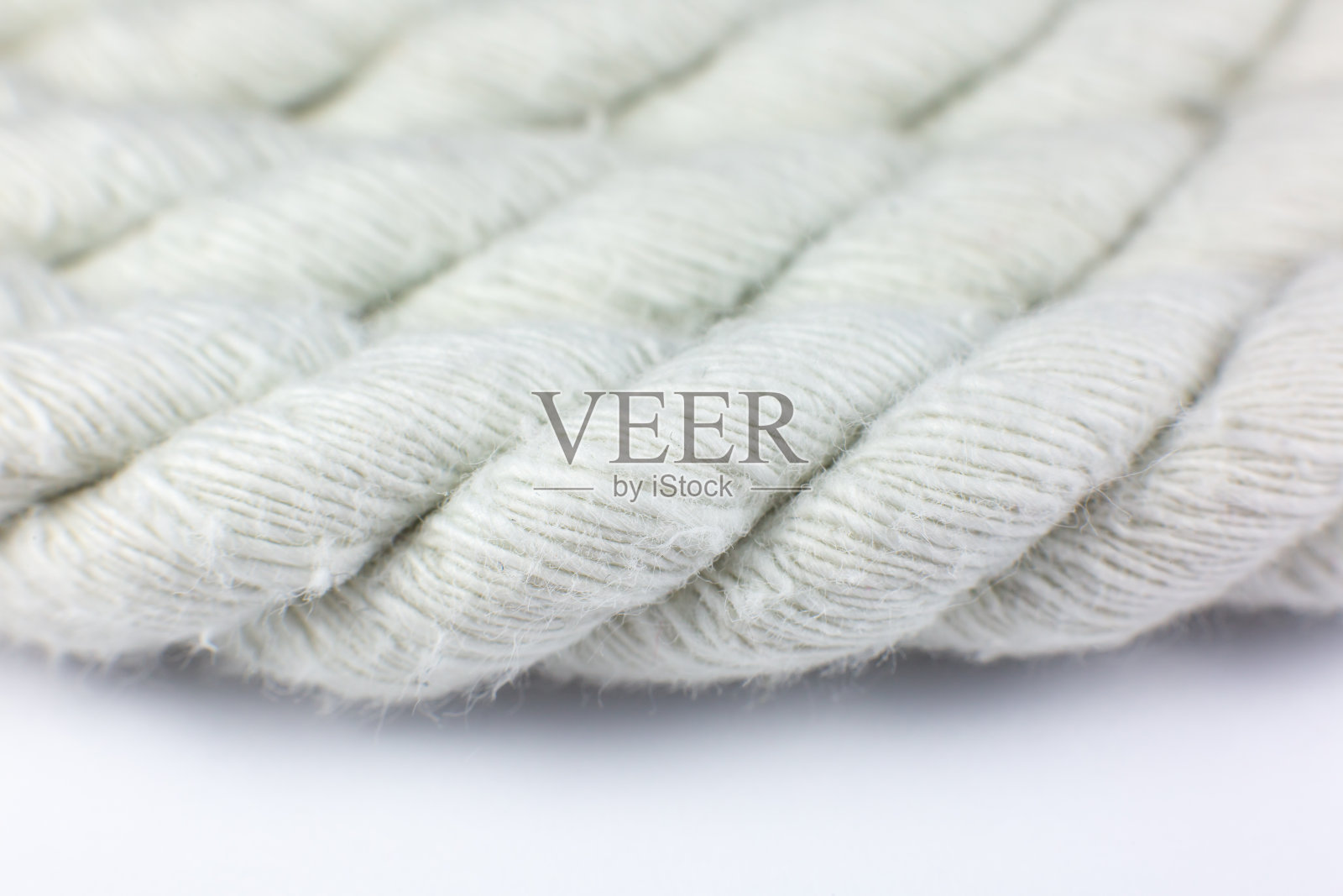 白色的棉绳卷在白色的背景上。照片摄影图片