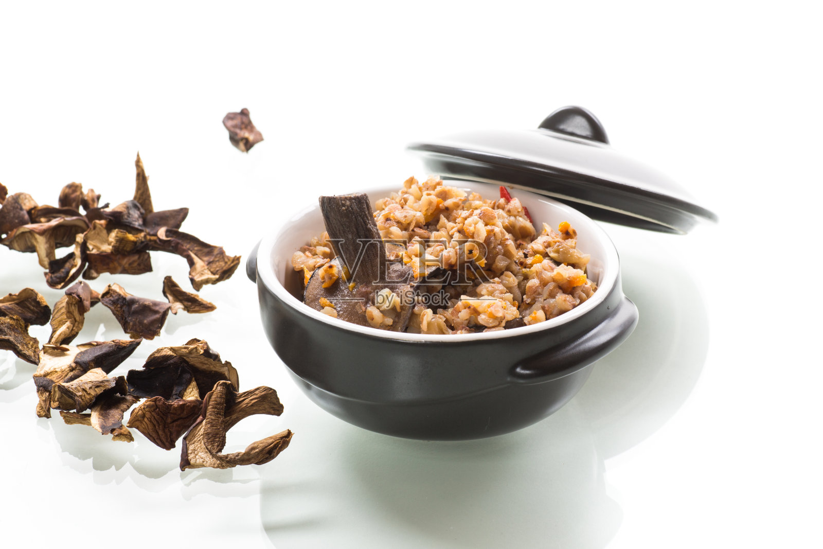 煮荞麦和有机森林干蘑菇在陶瓷碗照片摄影图片