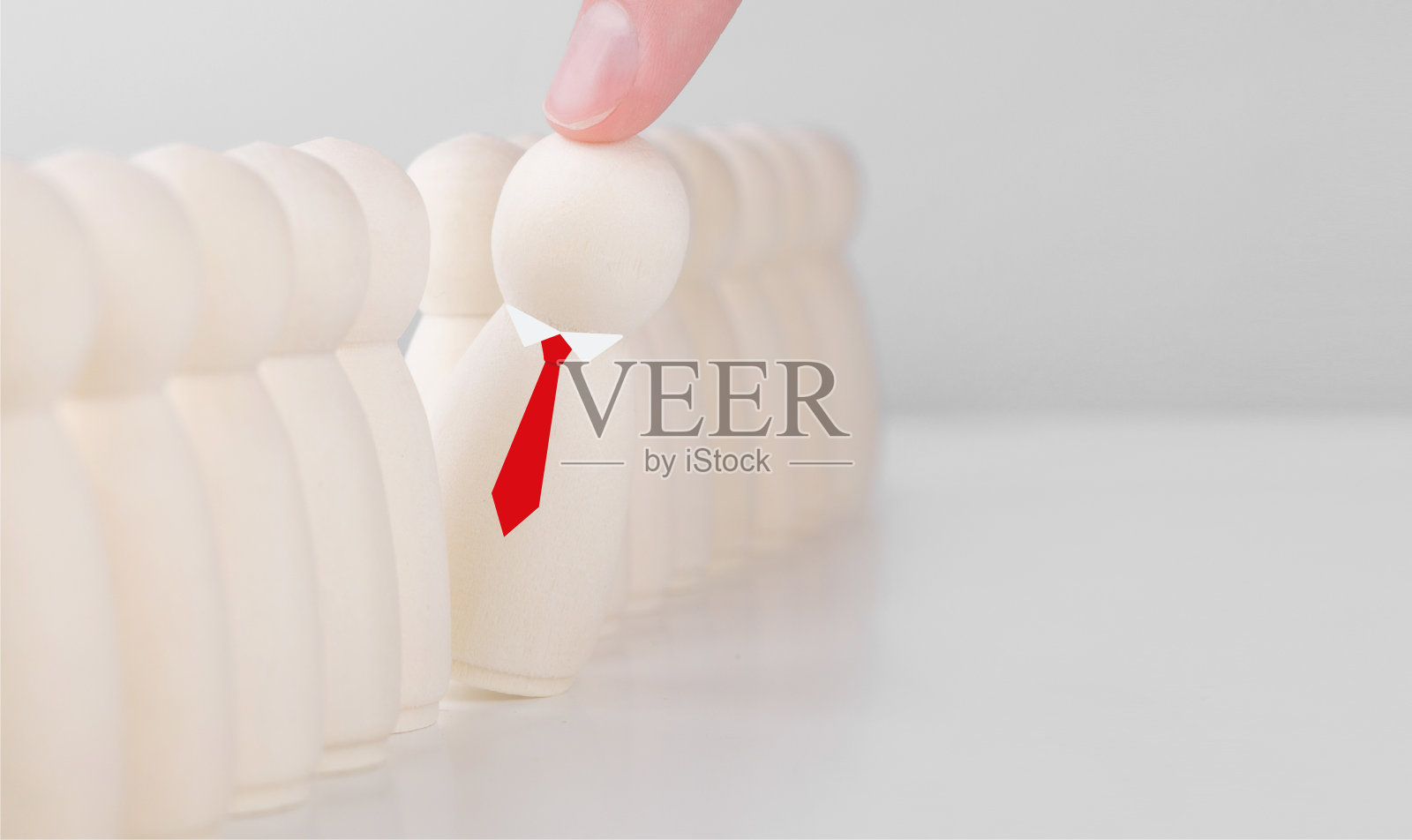 戴着红领带的木制商人从人群中脱颖而出。员工招聘。人力资源。人力资源、CEO和领导力的概念。照片摄影图片