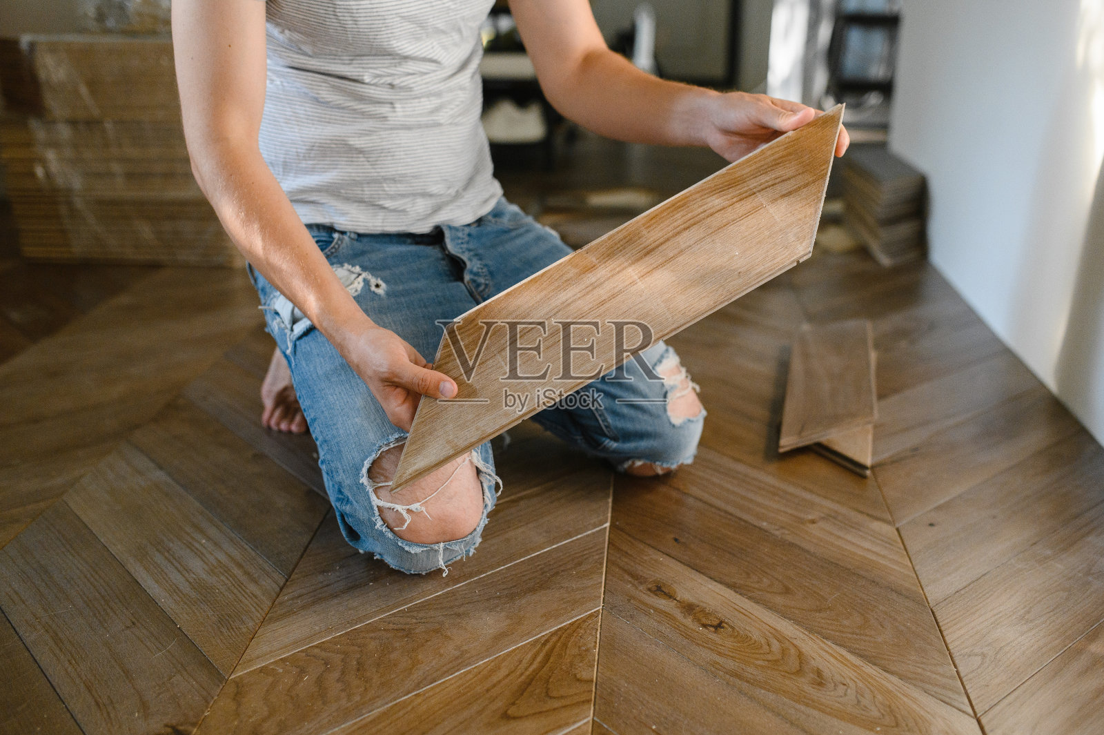 男子铺设拼花地板-特写男性的手。工人拼接拼花地板照片摄影图片
