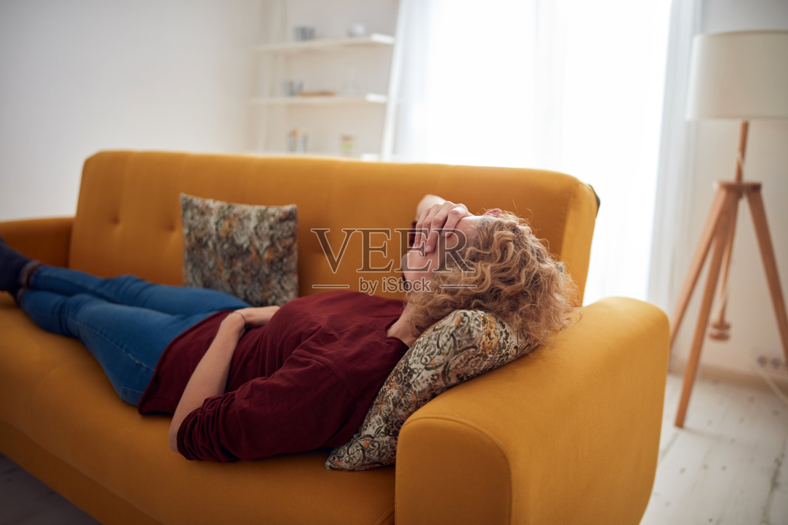 患有鼻窦疼痛、头痛和胃部问题的女人躺在沙发上照片摄影图片