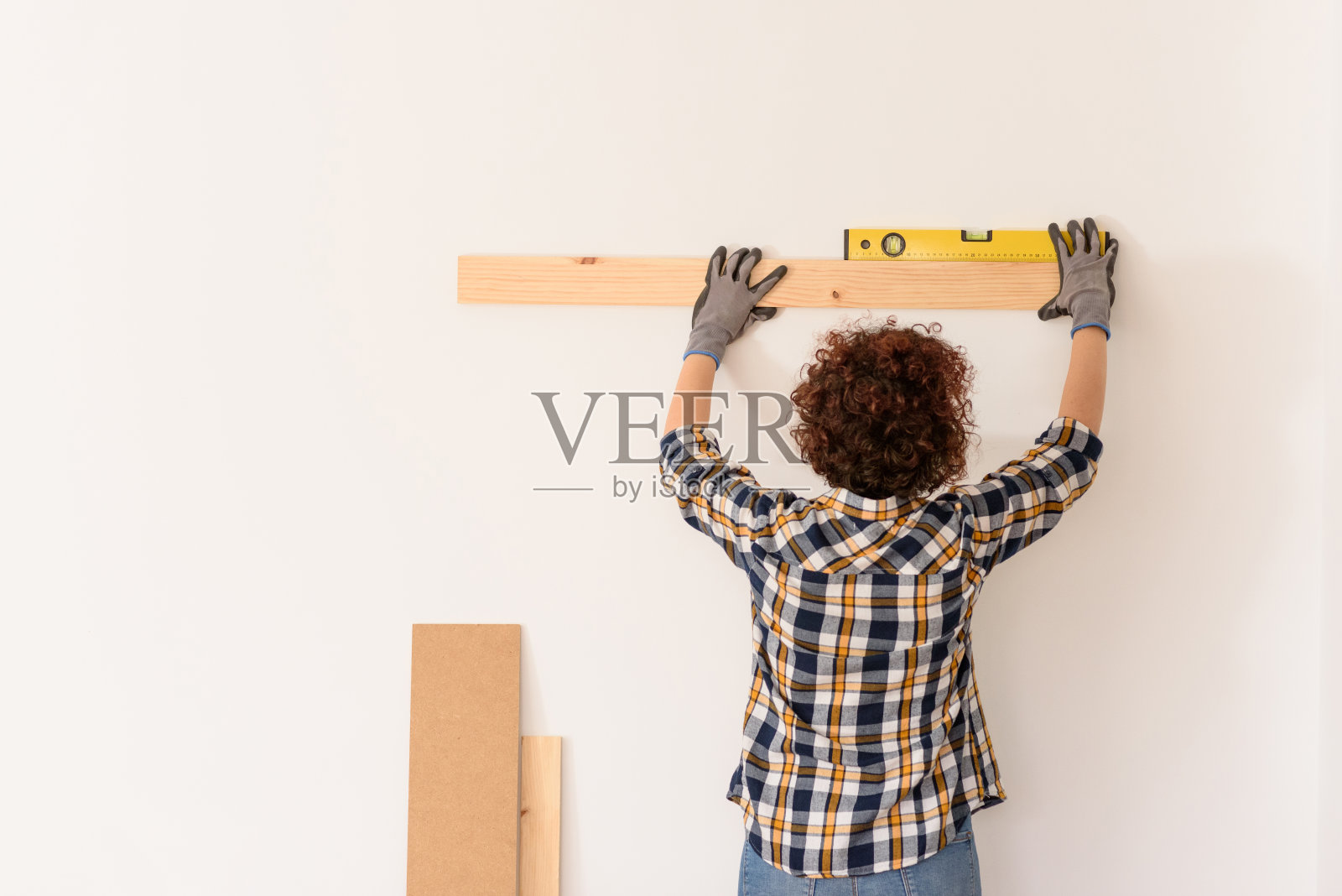 一个面目全非的女人用水平尺精确地放置一块木板照片摄影图片