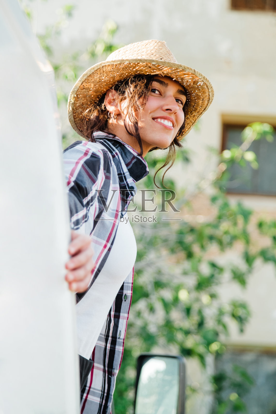 年轻的农妇坐在一辆面包车里看着农田照片摄影图片
