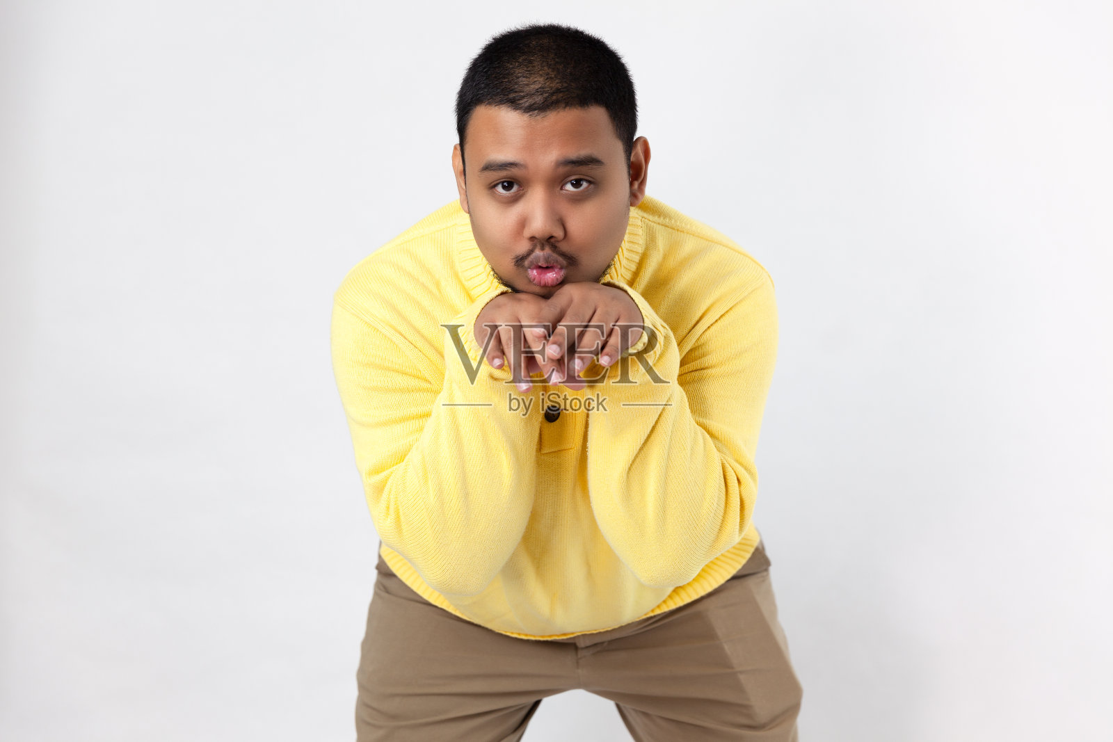 亚洲人在白色背景上做了一个有趣的脸照片摄影图片