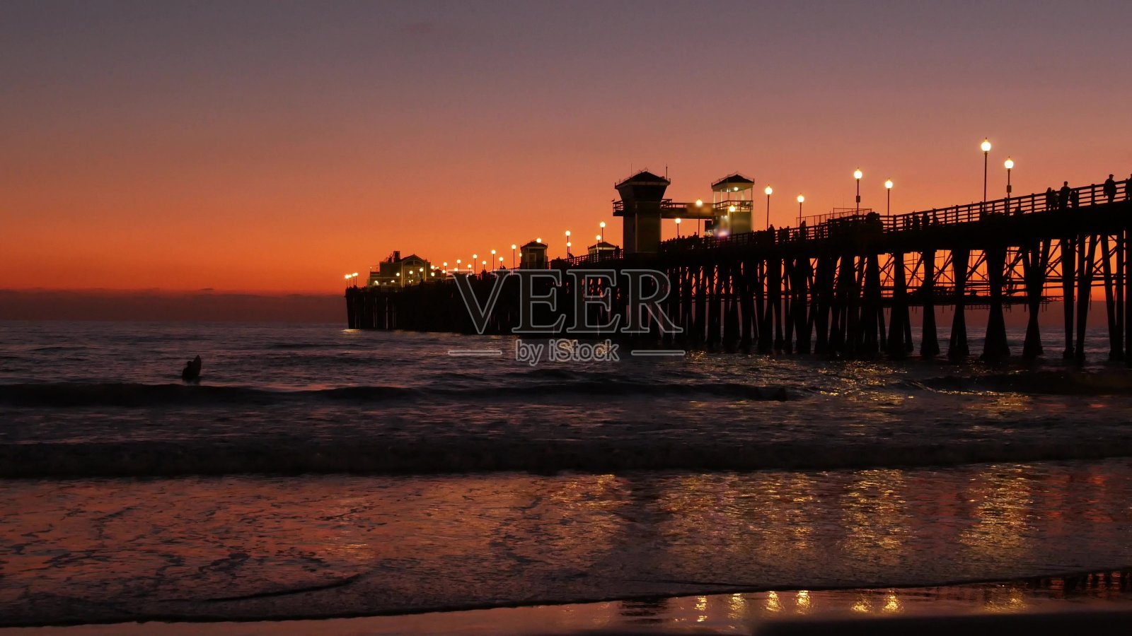日落时码头剪影，美国加州，海滨。冲浪度假村，海洋热带海滩。冲浪者等待海浪。照片摄影图片