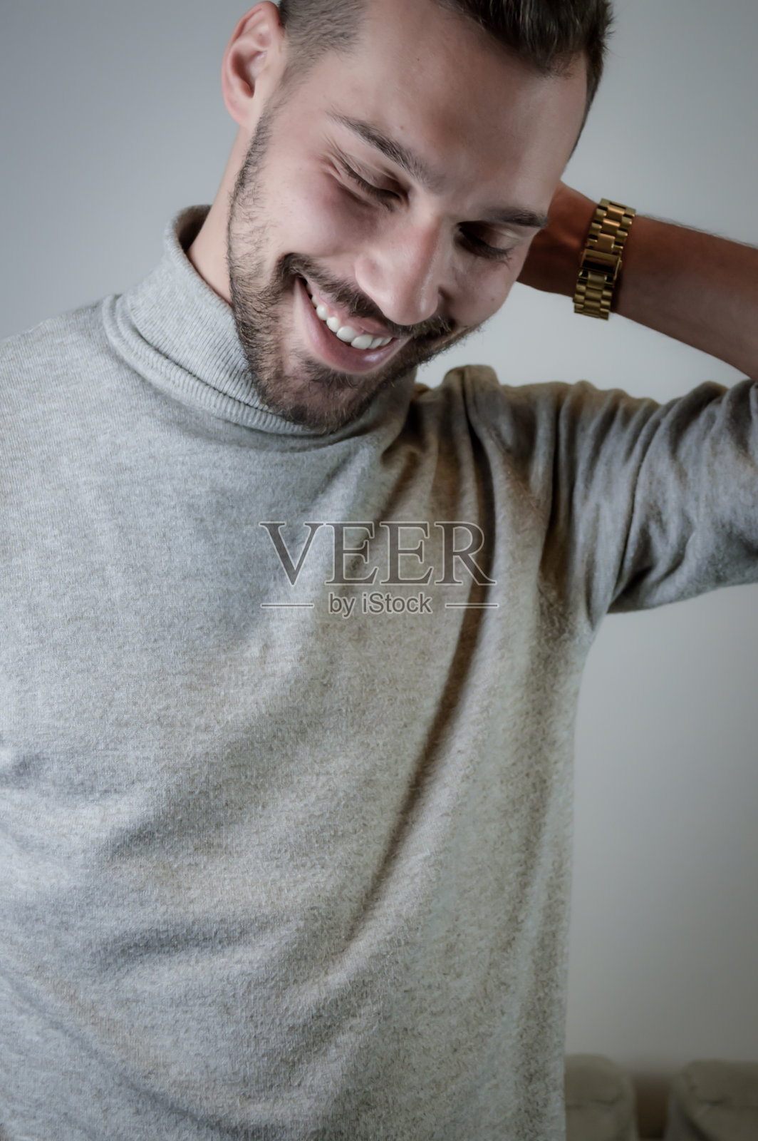 一个年轻男子的肖像与短胡子，在谈话中看起来很尴尬，并触摸他的头照片摄影图片