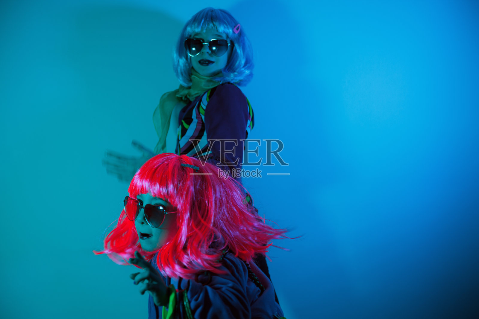 小女孩们戴着五颜六色的假发和心形太阳镜摆姿势拍照照片摄影图片