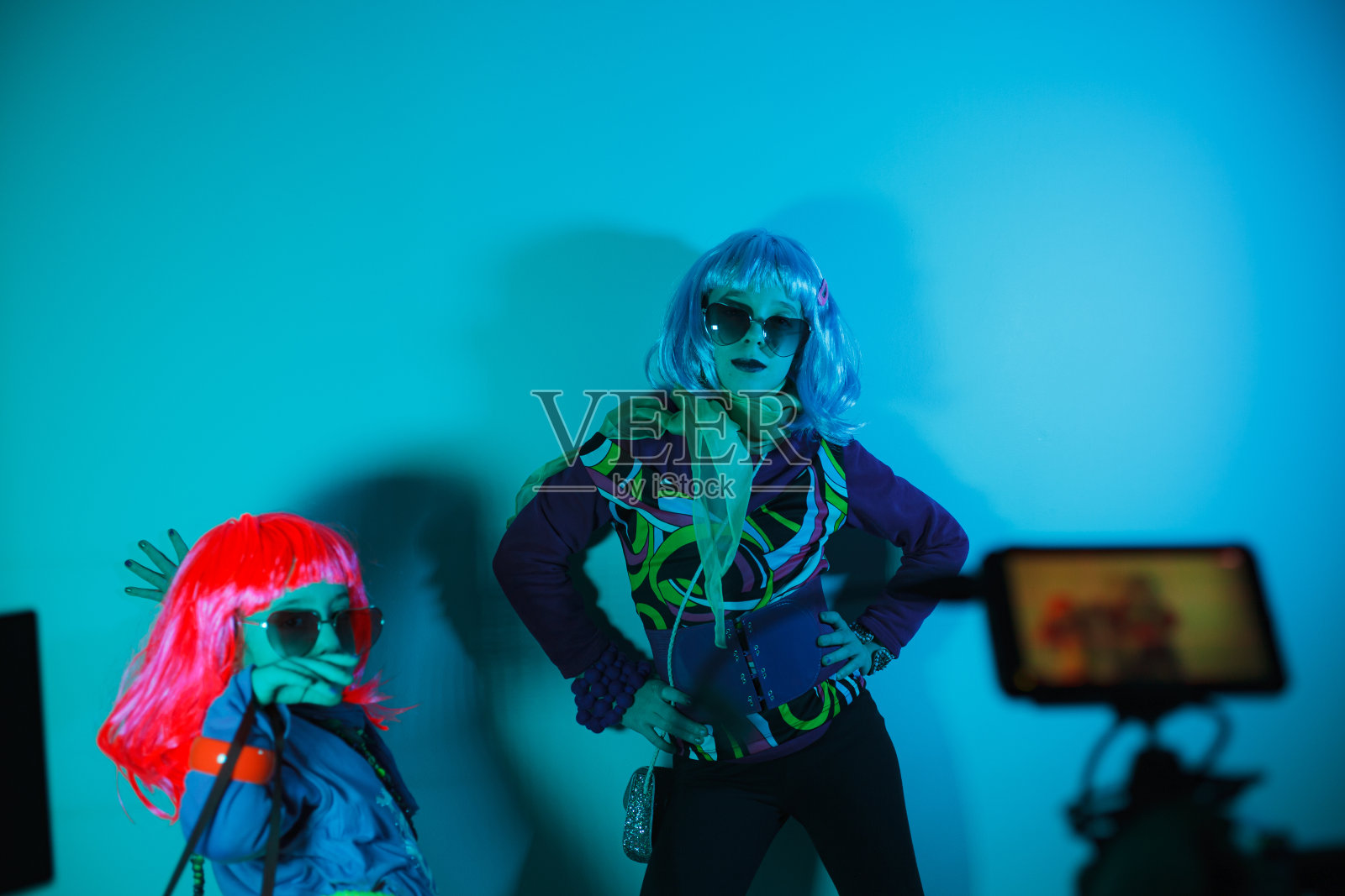 小女孩们戴着五颜六色的假发和心形太阳镜摆姿势拍照照片摄影图片