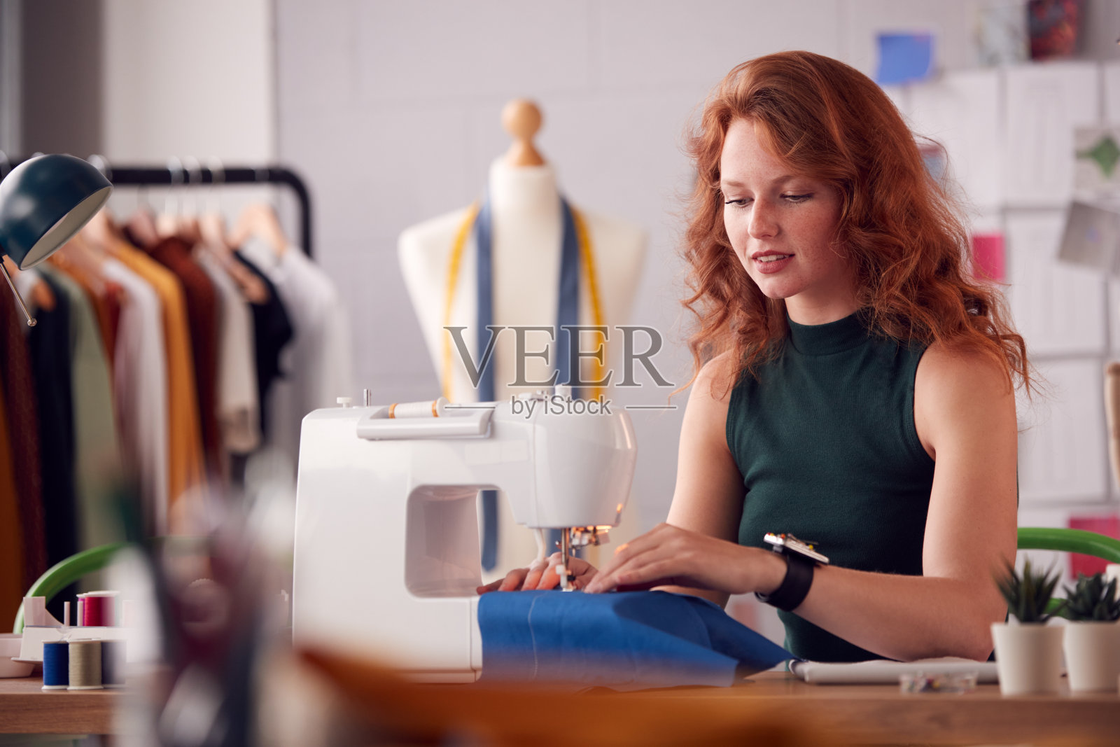 女学生或企业主使用缝纫机在时装工作室工作照片摄影图片