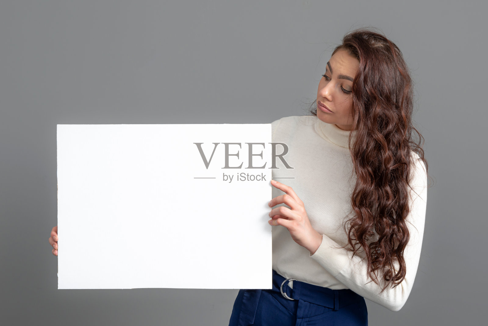 美丽性感的女人长卷发显示一个空白的旗帜，孤立在灰色，复制空间照片摄影图片