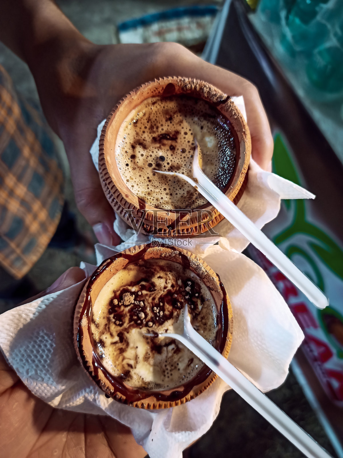 高角度观看两杯新鲜准备的冰巧克力茶在一个印度梅拉手里照片摄影图片