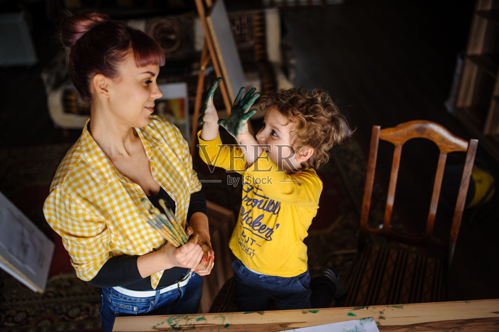 年轻的母亲和她的儿子玩彩色颜料照片摄影图片