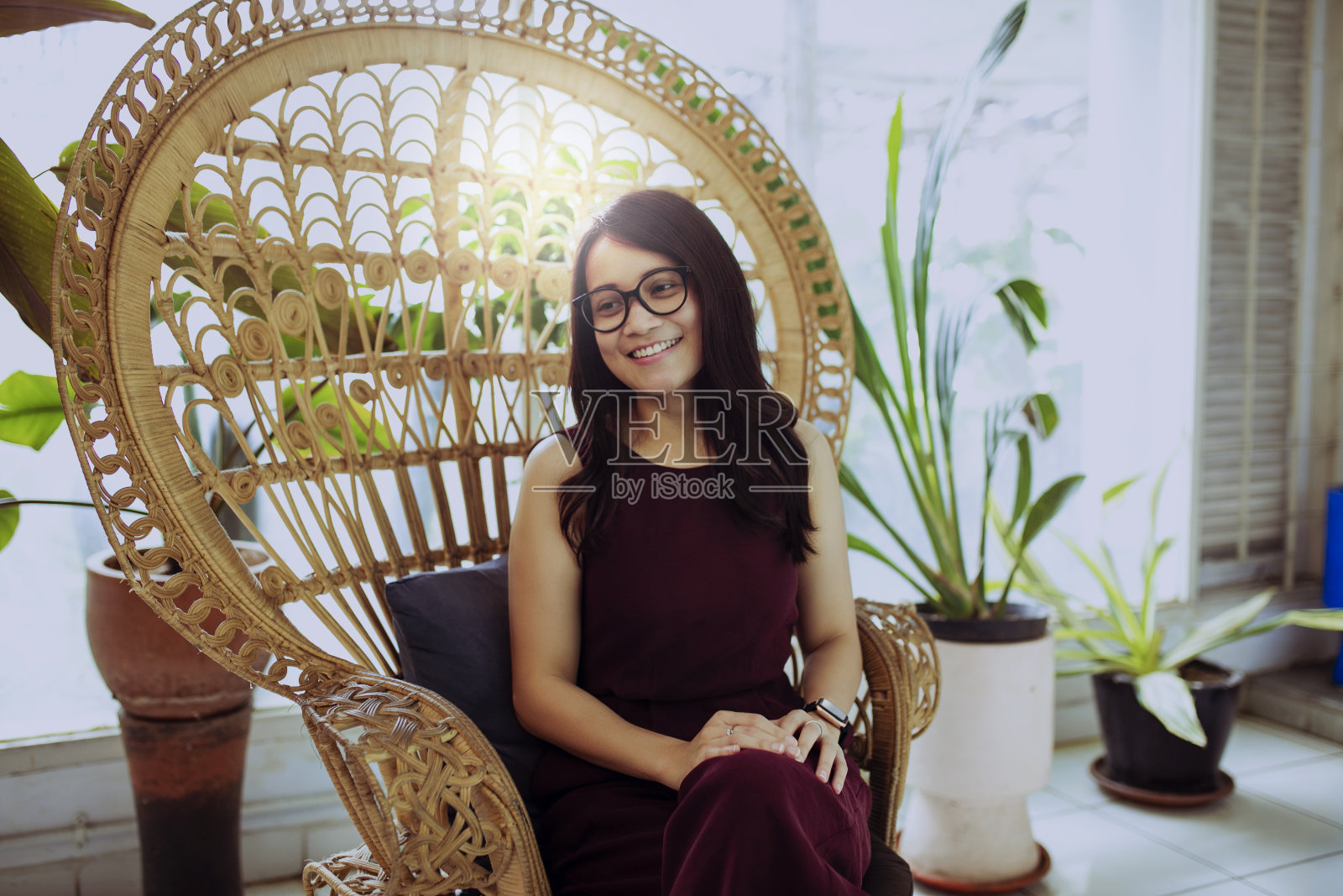 年轻的亚洲女人坐在沙发上照片摄影图片