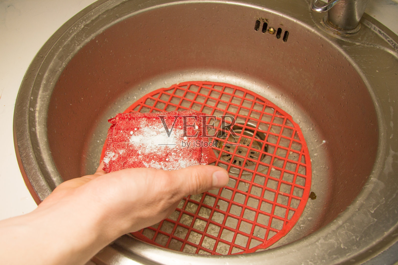 一个男人的手拿着海绵和洗衣粉要洗一个脏壳照片摄影图片