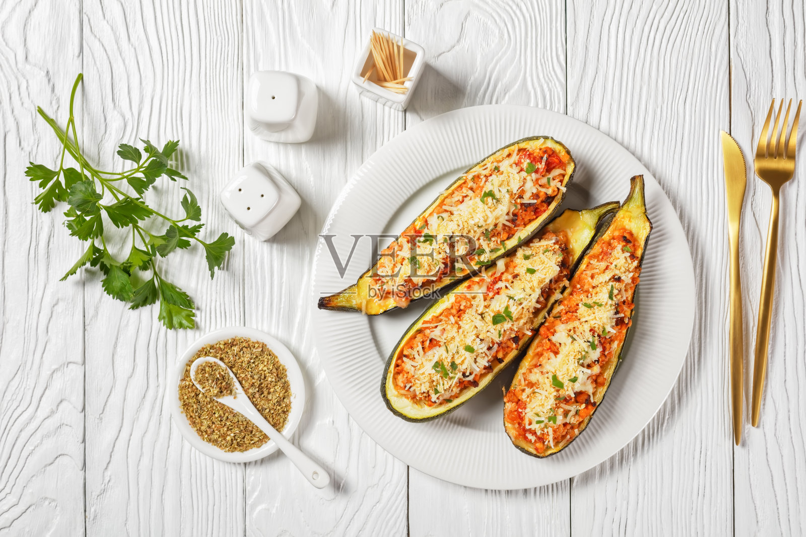 平底的木桌上放着一个白色的浅盘，里面塞满了碎肉、番茄和奶酪，这是意大利菜照片摄影图片