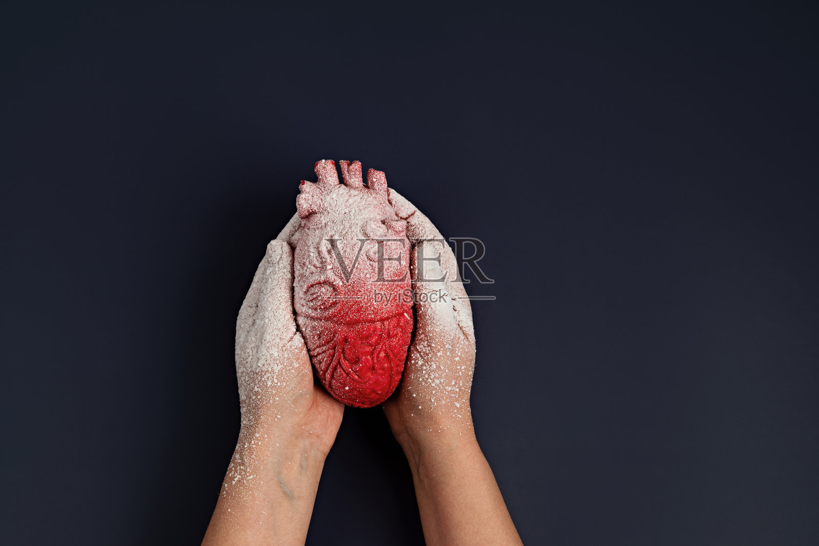 雪中女人手中的冰冻的心照片摄影图片