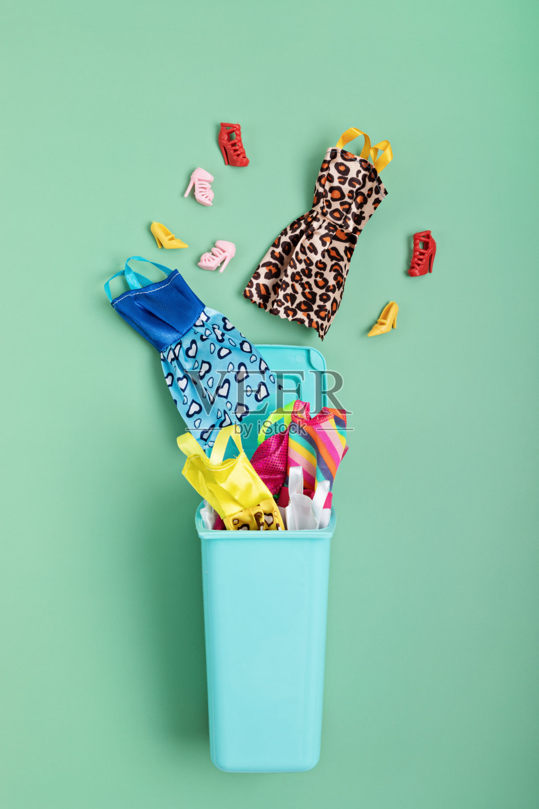 把衣服和鞋子扔进垃圾桶。大众时尚、循环利用、道德消费理念照片摄影图片