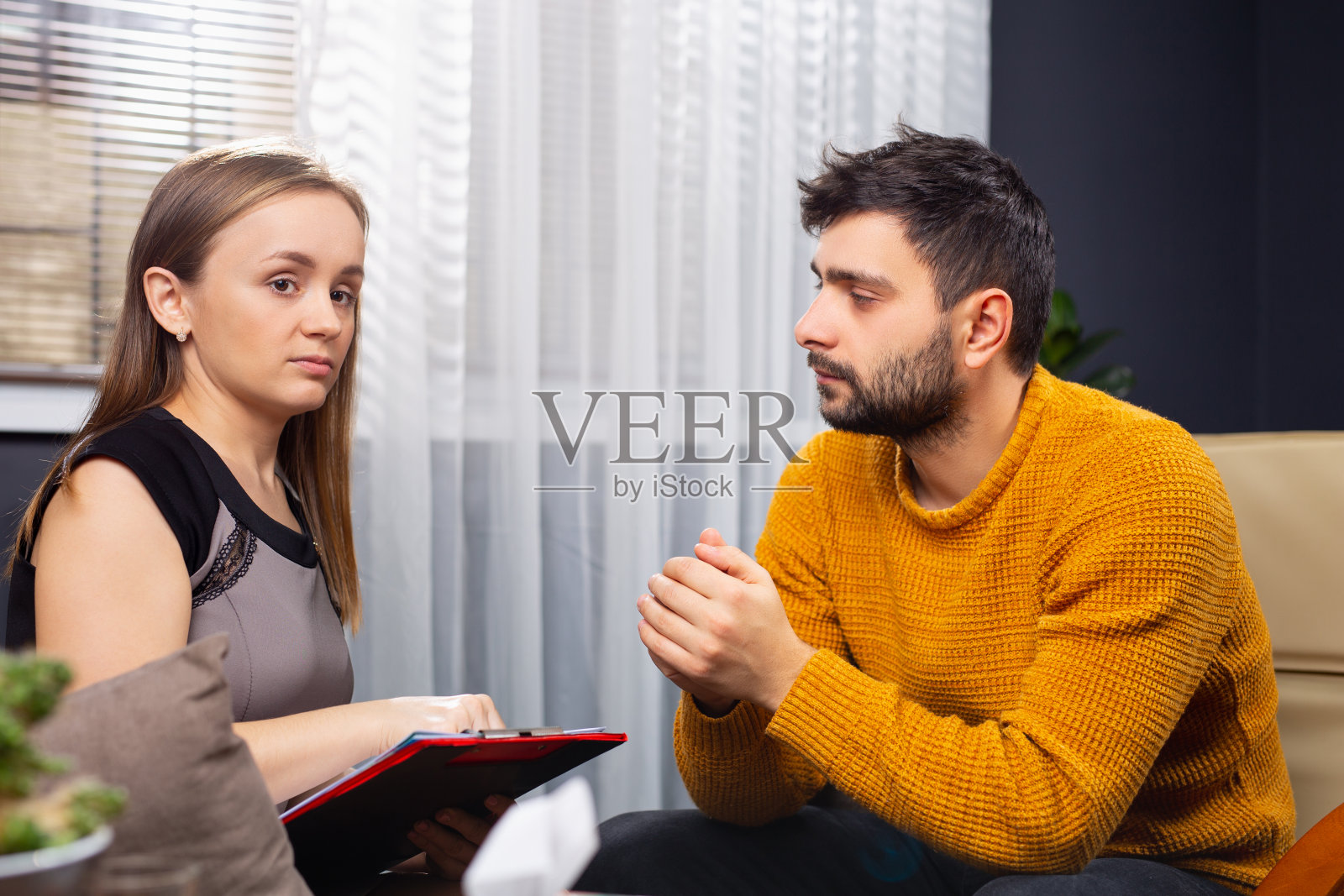 心理咨询：中年男士在心理治疗中与女心理医生交流照片摄影图片